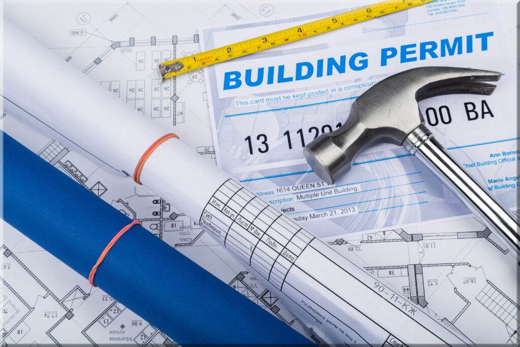 Building permits, blueprints, hammer and tape measure