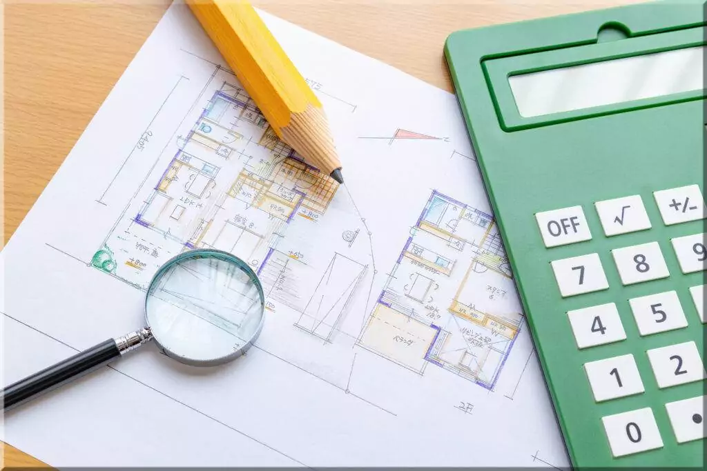 How To Estimate Your New Home Construction Costs- budget - Coats Construction Concepts LLC Sketched blueprints and a calculator